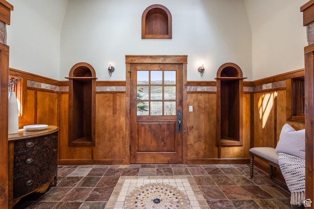 2000 W Red Hawk Trl, Park City, UT 84098 - foyer entrance featuring stone tile flooring, wainscoting, a towering ceiling, and wooden walls