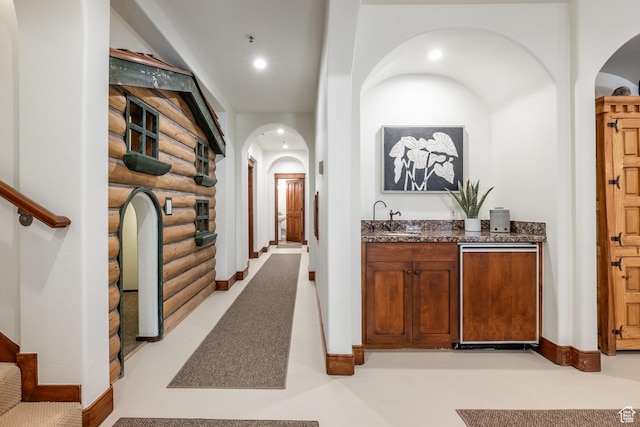 2000 W Red Hawk Trl, Park City, UT 84098 - hall featuring rustic walls, arched walkways, a sink, stairway, and baseboards