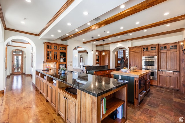 2000 W Red Hawk Trl, Park City, UT 84098 - kitchen with arched walkways, a spacious island, double oven, open shelves, and a warming drawer