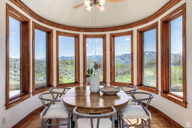 2000 W Red Hawk Trl, Park City, UT 84098 - dining area with baseboards, a ceiling fan, a mountain view, and dark wood-style flooring