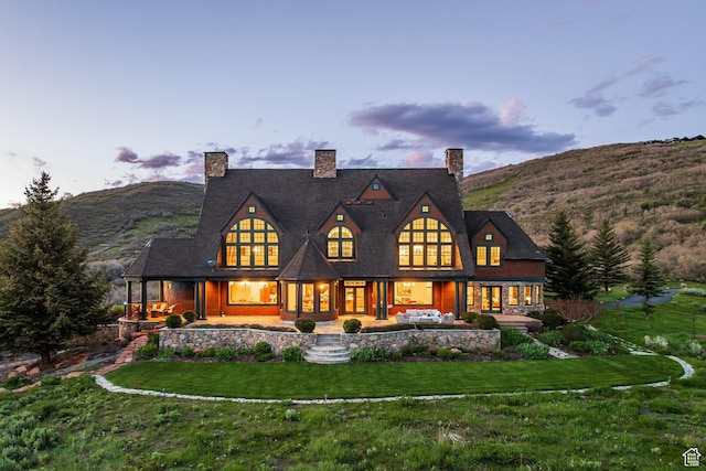 2000 W Red Hawk Trl, Park City, UT 84098 - back of property at dusk with a lawn, covered porch, a chimney, and a mountain view