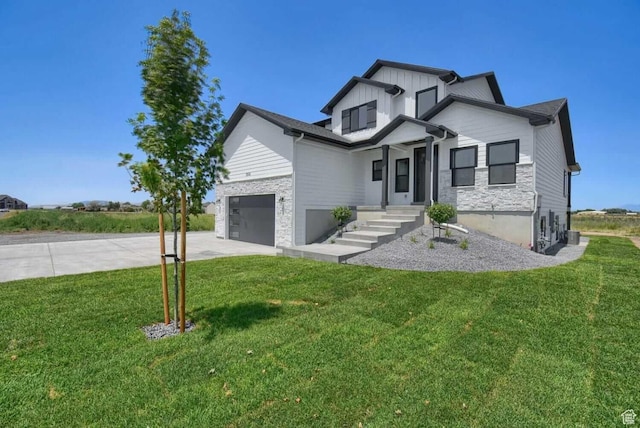 modern farmhouse style home with concrete driveway, a front lawn, board and batten siding, and stone siding
