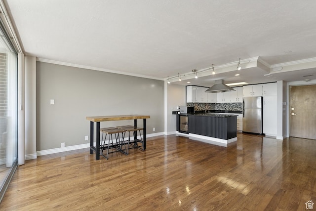 515 S 1000 E Unit 202, Salt Lake City, UT 84102 - kitchen with freestanding refrigerator, dark countertops, white cabinetry, ornamental molding, and tasteful backsplash