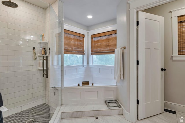 bathroom with a stall shower, a garden tub, baseboards, and recessed lighting