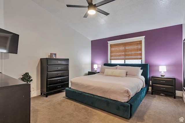 bedroom featuring light colored carpet, vaulted ceiling, a textured ceiling, a ceiling fan, and baseboards