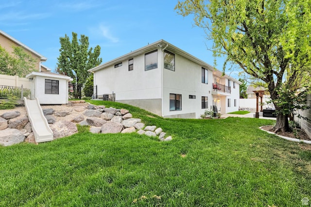 rear view of house featuring stucco siding and a balcony