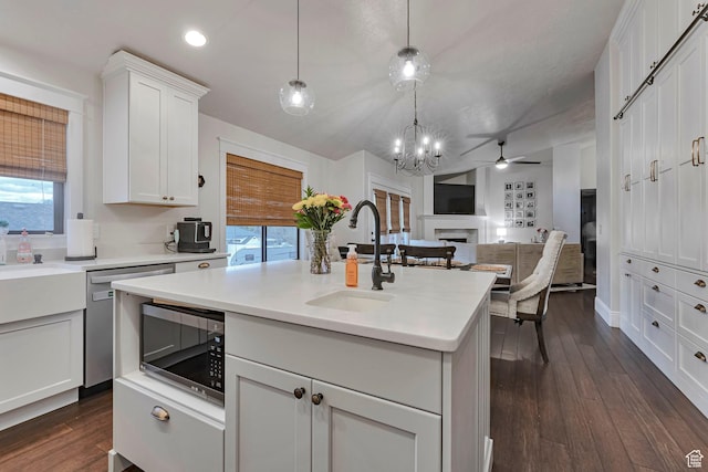 kitchen with a sink, stainless steel appliances, a fireplace, healthy amount of natural light, and recessed lighting