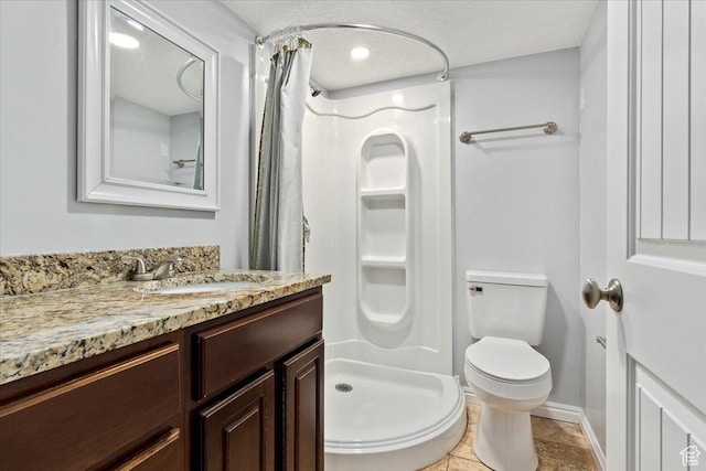 bathroom featuring a stall shower, toilet, vanity, and baseboards