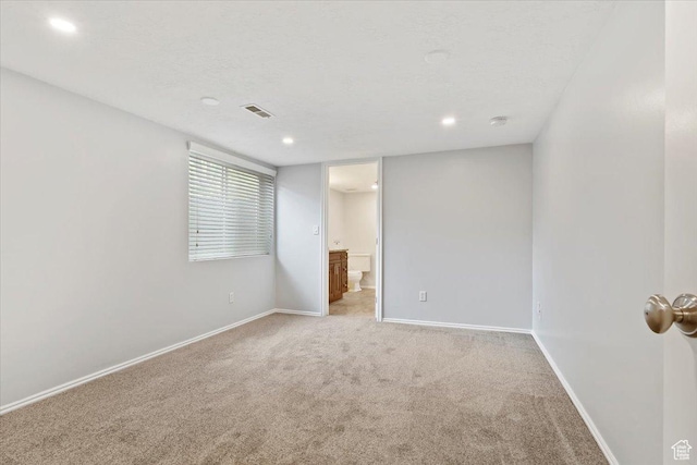 empty room featuring light colored carpet, baseboards, and recessed lighting