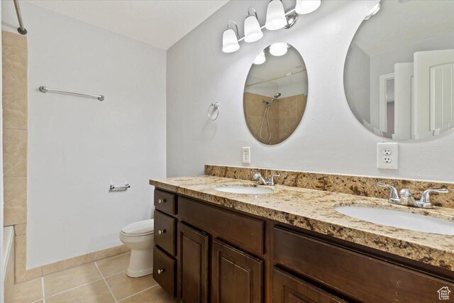 bathroom featuring toilet, tile patterned floors, and double vanity
