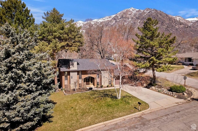 384 W 4200 N, Pleasant View, UT 84414 - view of front of property with a front yard, concrete driveway, a mountain view, brick siding, and a chimney