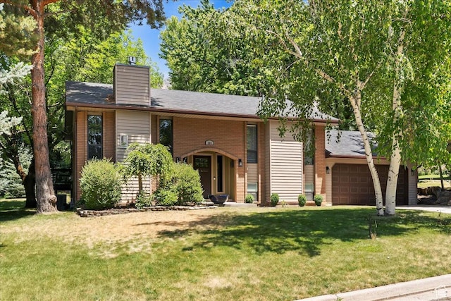 384 W 4200 N, Pleasant View, UT 84414 - view of front of home with an attached garage, a front lawn, a chimney, and brick siding
