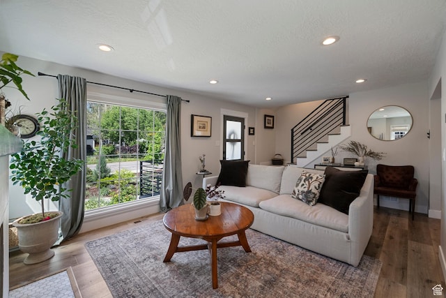 living area featuring stairway, a textured ceiling, wood finished floors, and recessed lighting