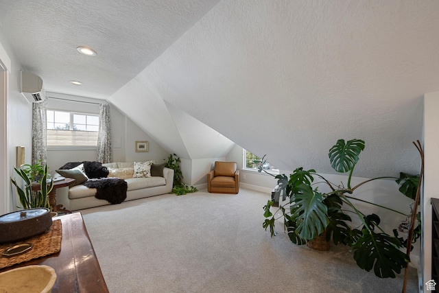 carpeted living room with vaulted ceiling, a wall unit AC, and a textured ceiling