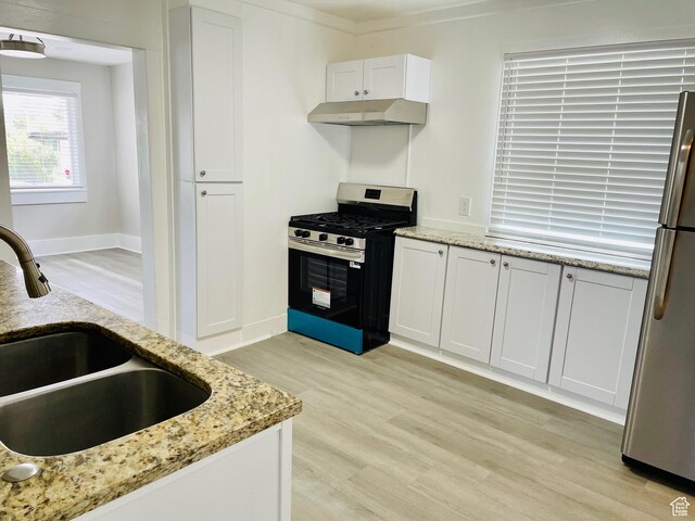 936 E Atkin Ave, Salt Lake City, UT 84106 - kitchen featuring stainless steel appliances, a sink, under cabinet range hood, light wood-type flooring, and white cabinetry