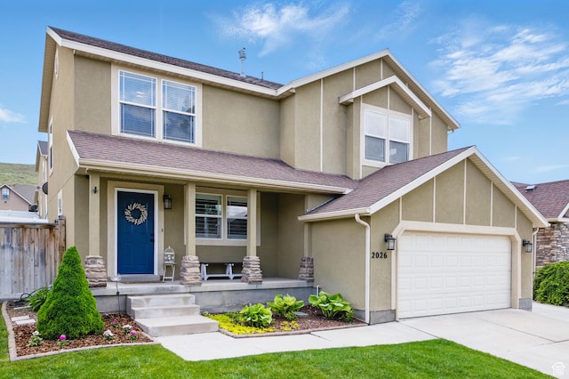 view of front facade with stucco siding, covered porch, concrete driveway, and an attached garage