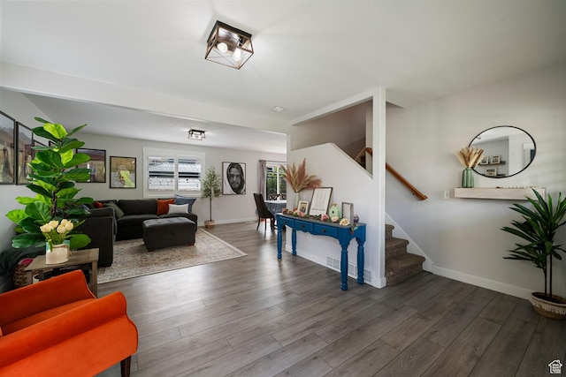 living area with stairway, wood finished floors, and baseboards