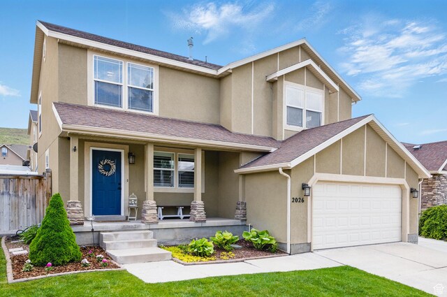 2026 E Ficus Way, Eagle Mountain, UT 84005 - view of front of home featuring a porch, stucco siding, driveway, an attached garage, and stone siding