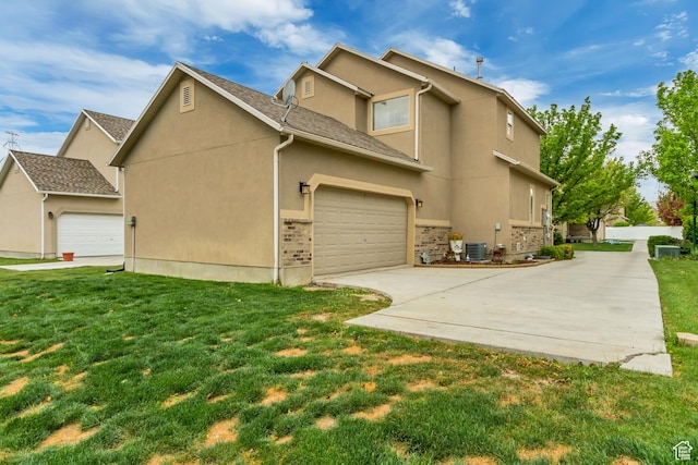 view of home's exterior featuring concrete driveway, stucco siding, a yard, and central AC unit