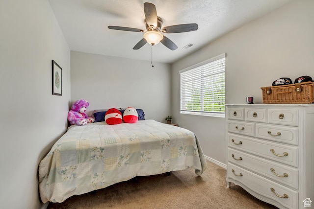 bedroom featuring light carpet, a ceiling fan, and baseboards