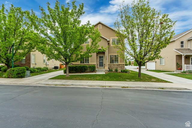 view of property hidden behind natural elements with stucco siding, driveway, a garage, and a front lawn