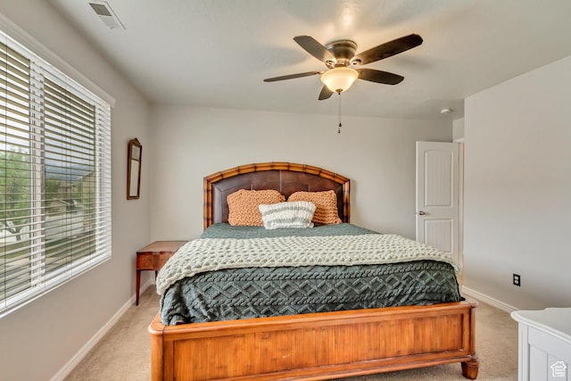 bedroom featuring light carpet, multiple windows, and baseboards