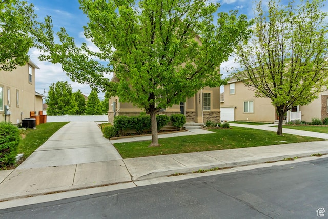 view of front of home featuring a front lawn, central AC, and stucco siding