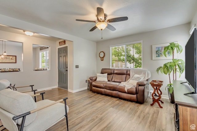 living room with healthy amount of natural light, light wood-type flooring, and baseboards
