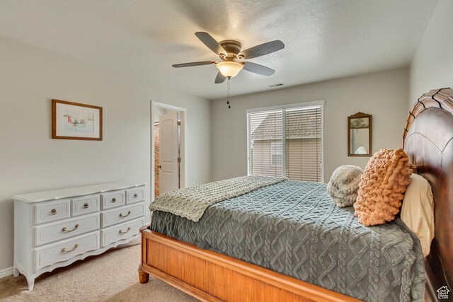 bedroom with light colored carpet, ensuite bath, ceiling fan, and baseboards
