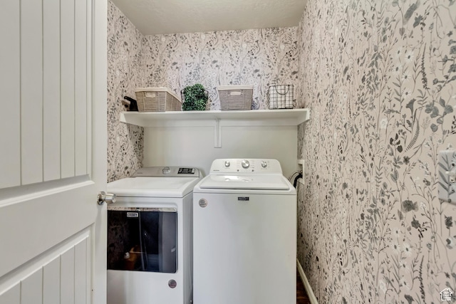 washroom featuring washing machine and dryer, wallpapered walls, and wood finished floors