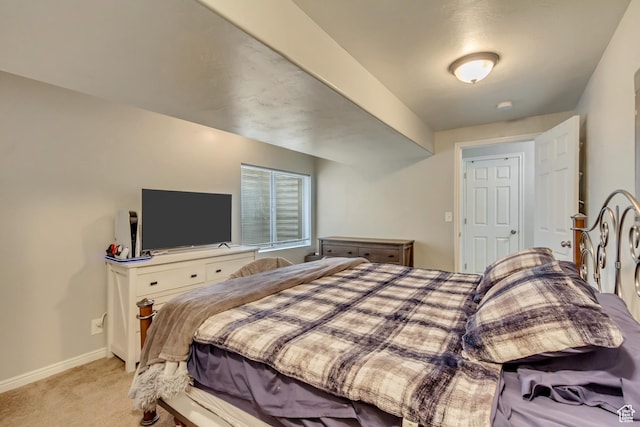 bedroom featuring light colored carpet and baseboards