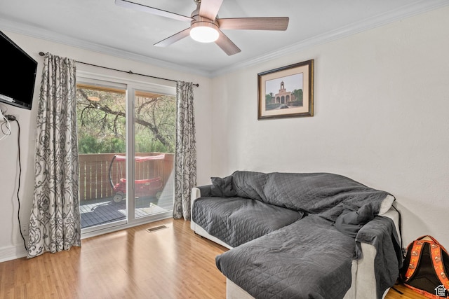living room featuring wood finished floors, ornamental molding, and ceiling fan