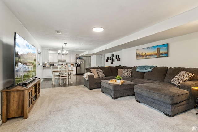 living area featuring a chandelier and carpet flooring
