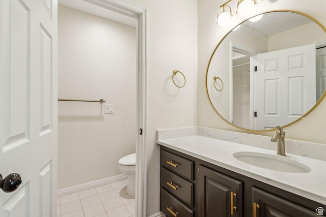 bathroom featuring toilet, vanity, tile patterned flooring, and baseboards