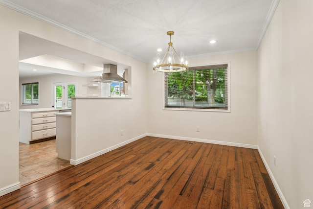 empty room with hardwood / wood-style flooring, a chandelier, crown molding, baseboards, and recessed lighting