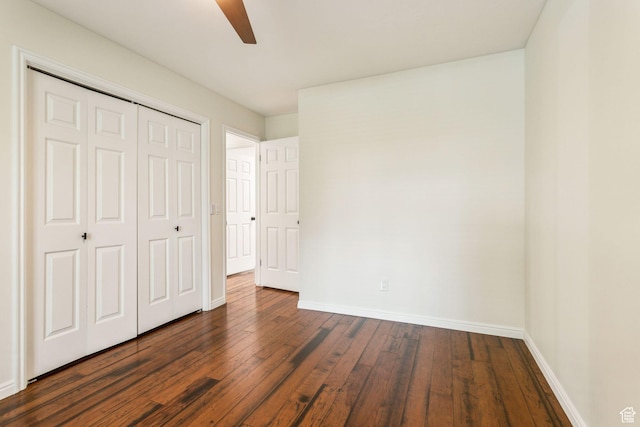 unfurnished bedroom featuring dark wood-style floors, baseboards, a closet, and a ceiling fan