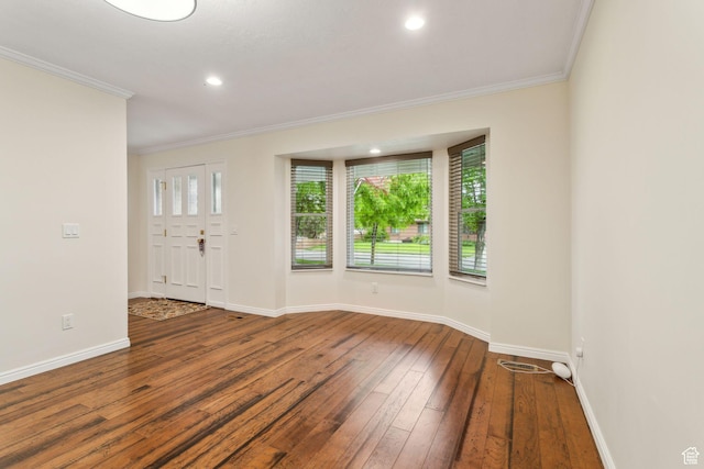 empty room with ornamental molding, wood-type flooring, baseboards, and recessed lighting