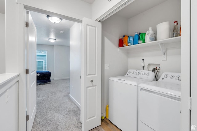 laundry room with separate washer and dryer, light carpet, and baseboards