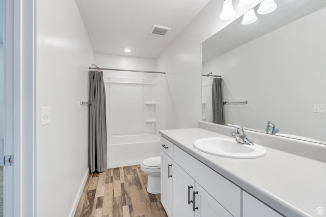 bathroom with wood finished floors, toilet, vanity, shower / tub combo, and recessed lighting