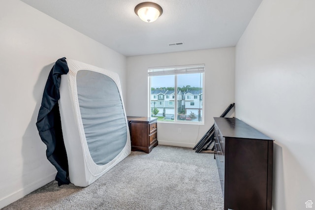 bedroom featuring light carpet and baseboards