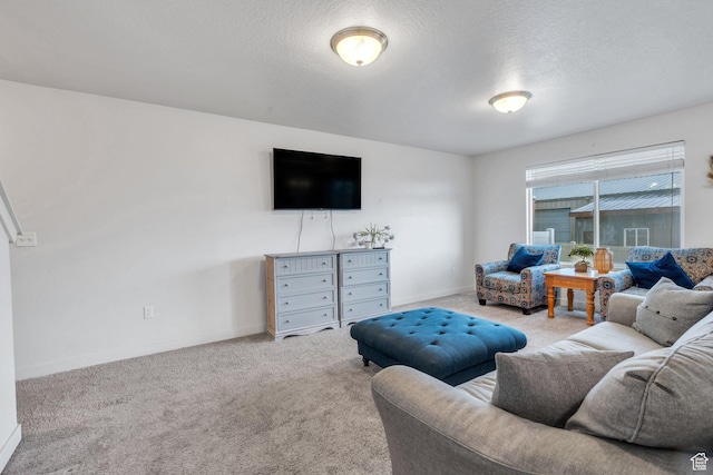 living area featuring carpet flooring, baseboards, and a textured ceiling