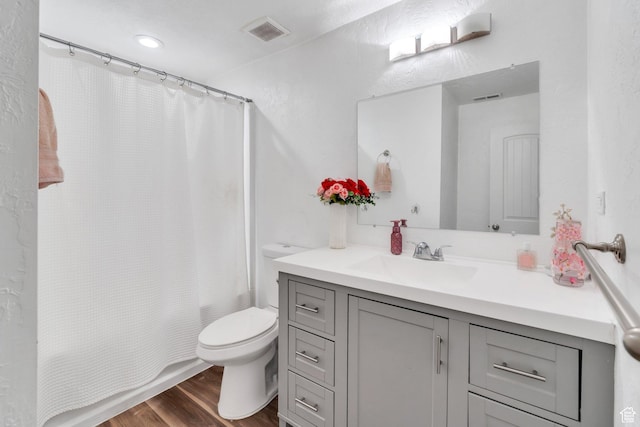 full bath with wood finished floors, toilet, vanity, and shower / bath combination with curtain