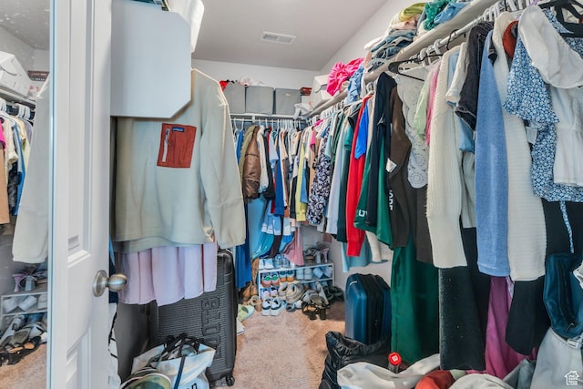 walk in closet featuring carpet flooring
