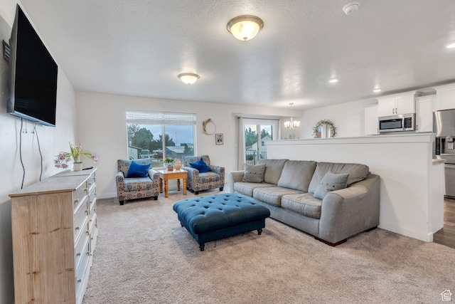 living room featuring a chandelier, carpet, and baseboards