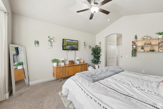bedroom with lofted ceiling, arched walkways, carpet flooring, and ceiling fan