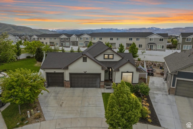 view of front of property with stucco siding, a mountain view, concrete driveway, and an attached garage