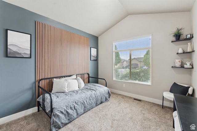 carpeted bedroom featuring vaulted ceiling and baseboards