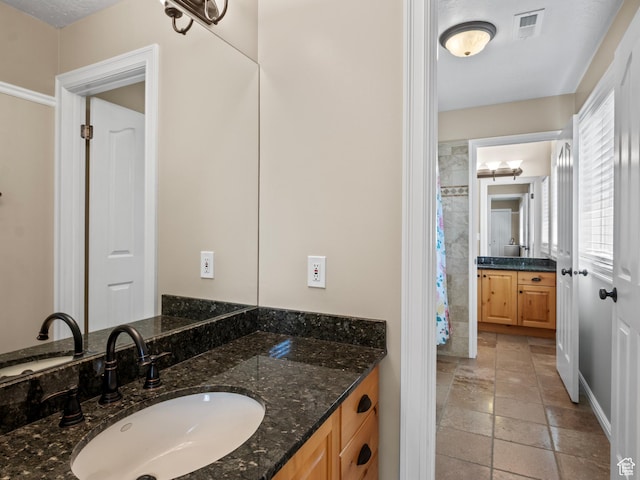 full bathroom featuring stone tile floors and vanity