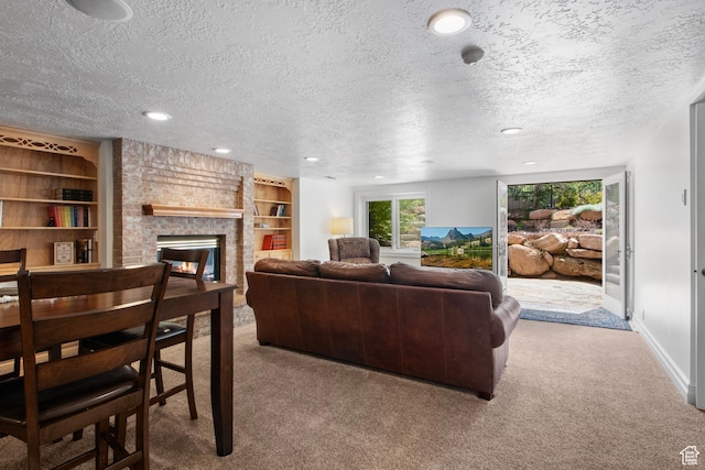 carpeted living room featuring a fireplace, a textured ceiling, baseboards, recessed lighting, and built in shelves