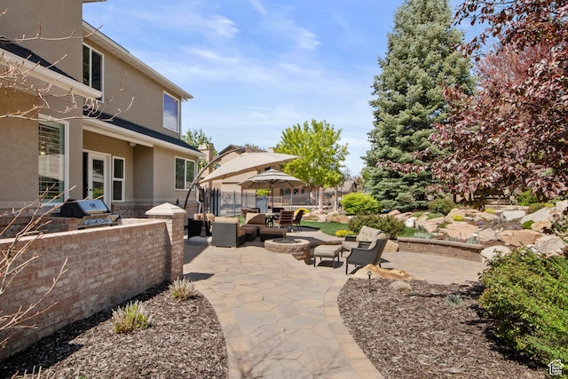 view of patio / terrace with area for grilling, an outdoor fire pit, fence, and a grill
